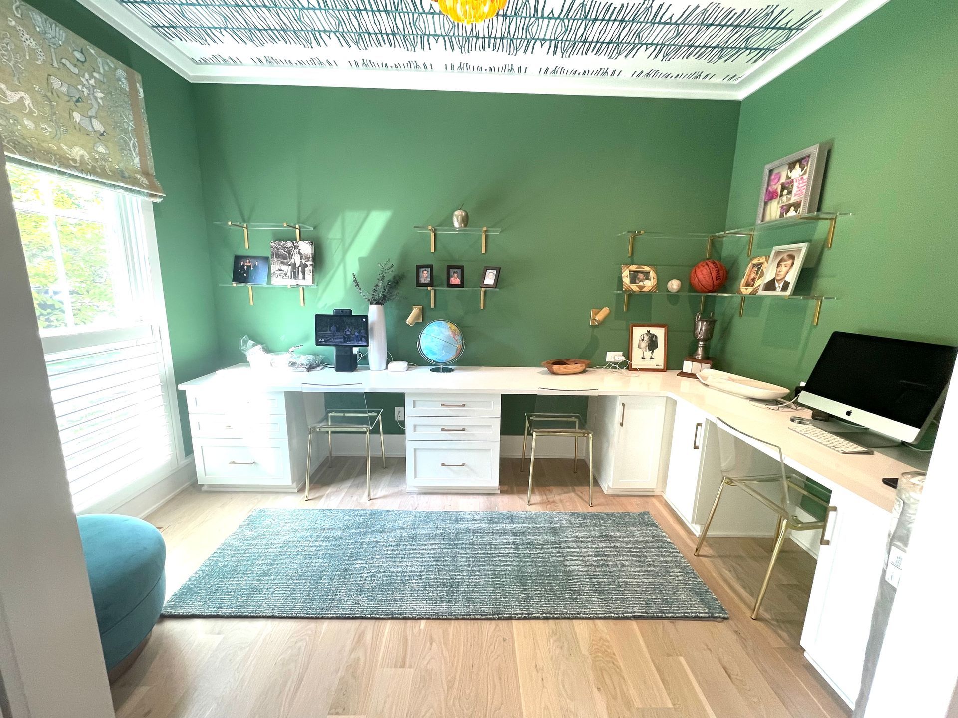 A room with green walls and a desk with a computer on it.