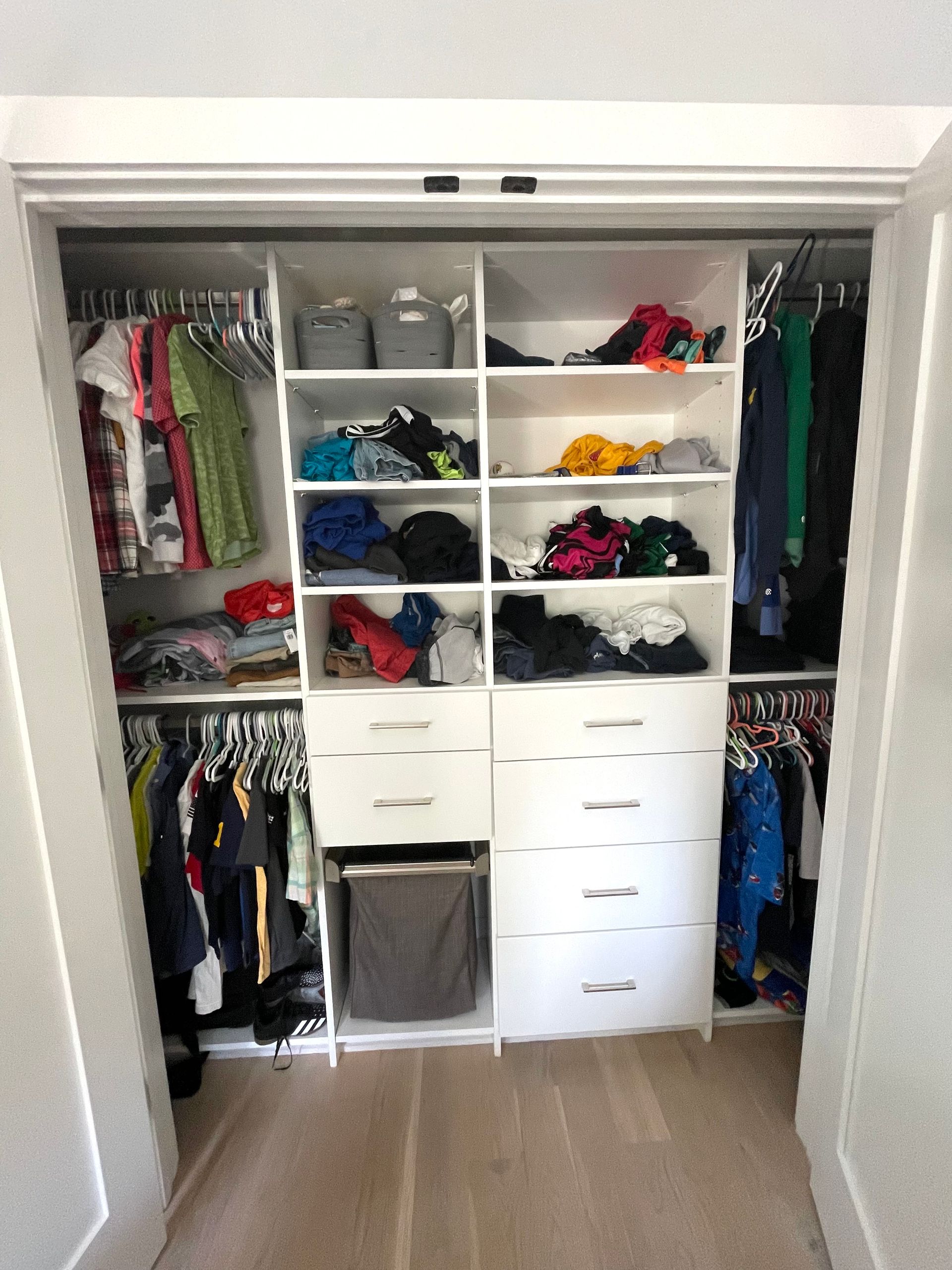 A closet filled with lots of clothes and drawers.