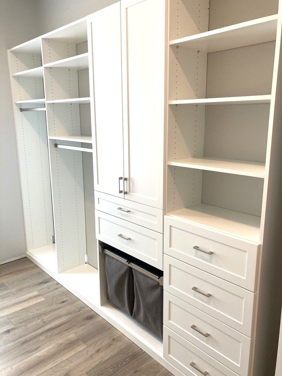 A walk in closet with lots of shelves and drawers.