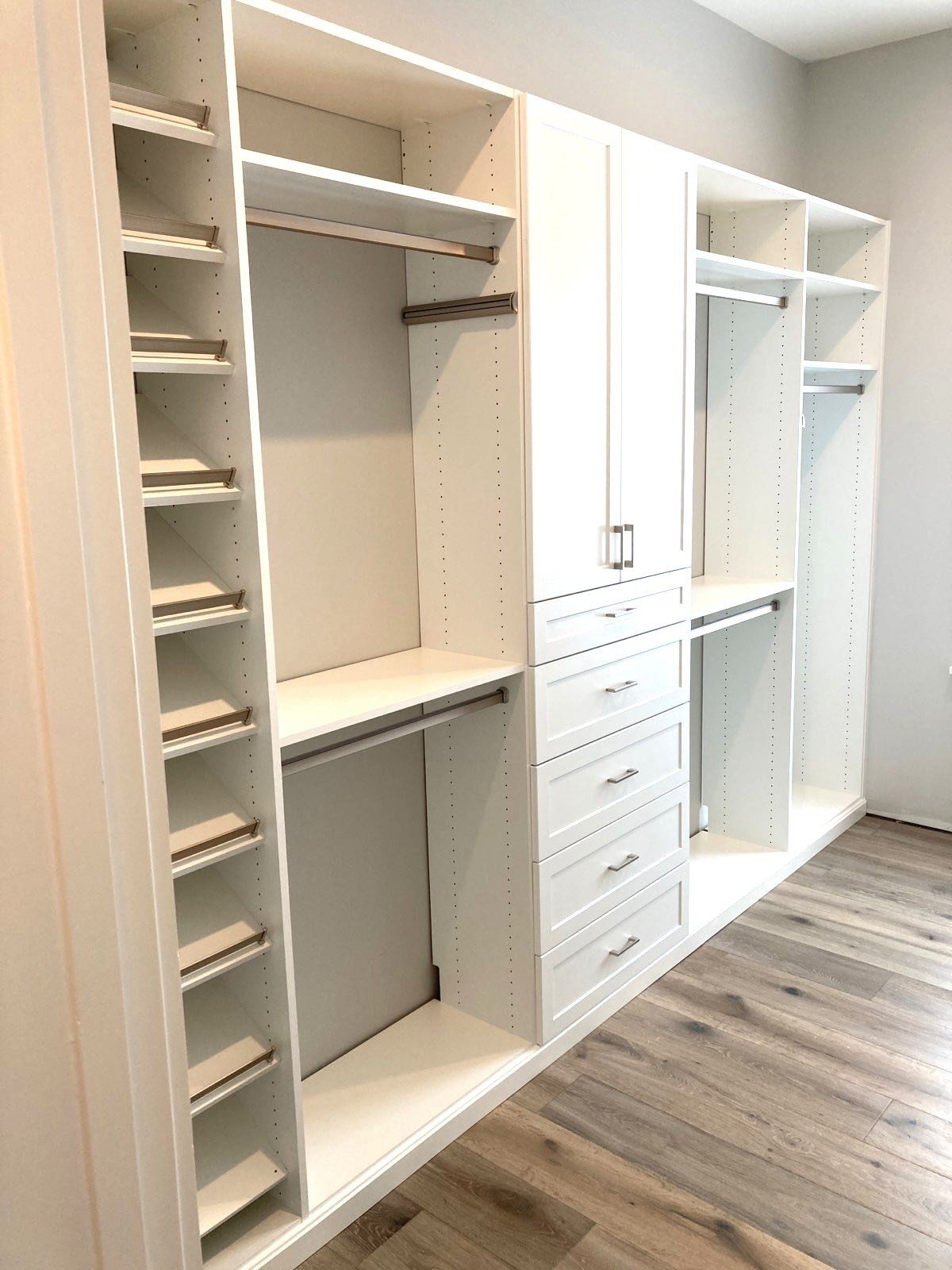 A walk in closet with lots of shelves and drawers.