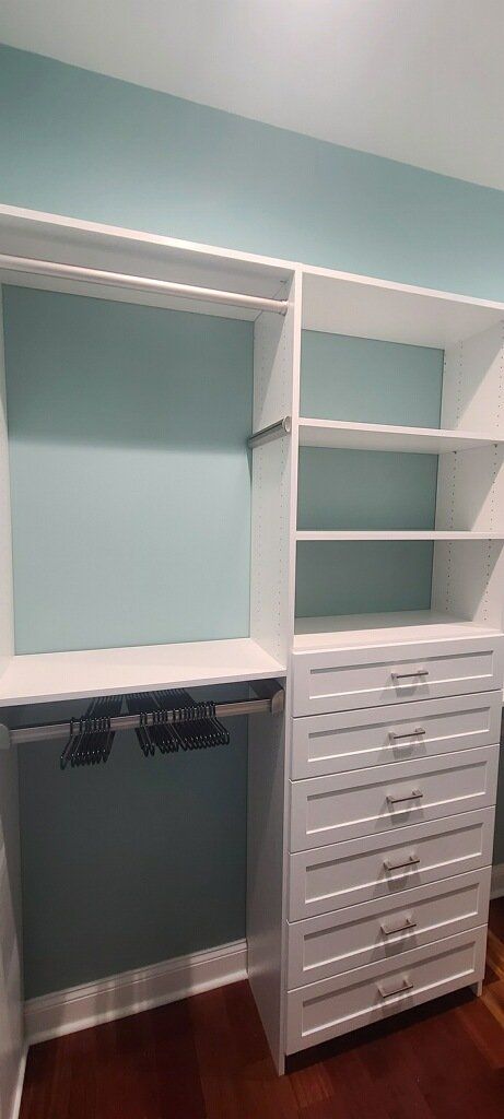 A walk in closet with lots of shelves and drawers.