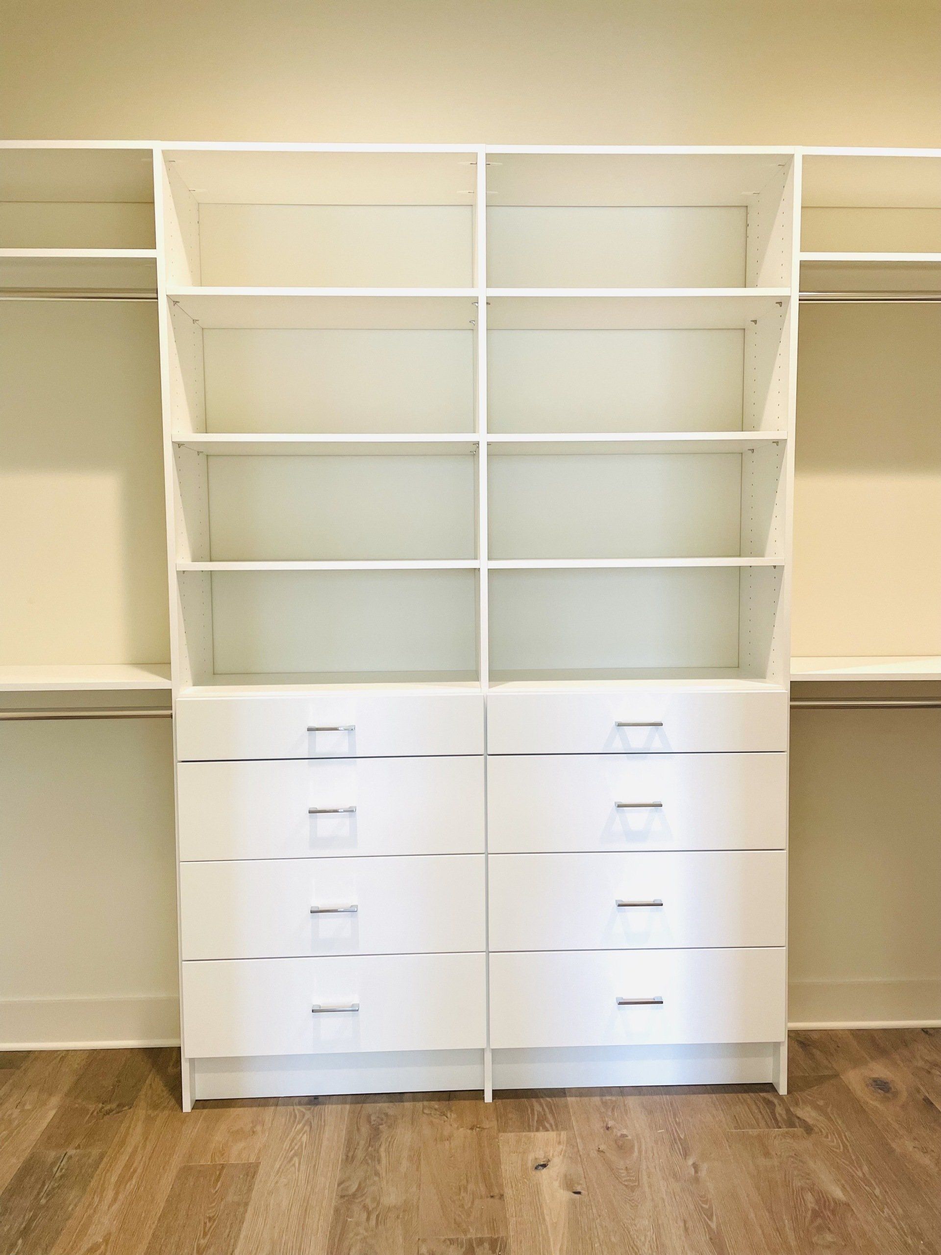 A walk in closet with lots of shelves and drawers.