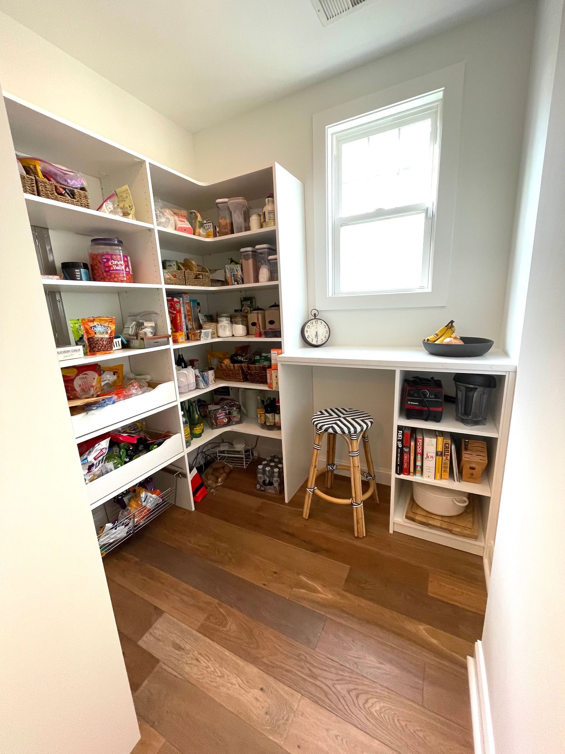 A pantry filled with lots of food and a desk.