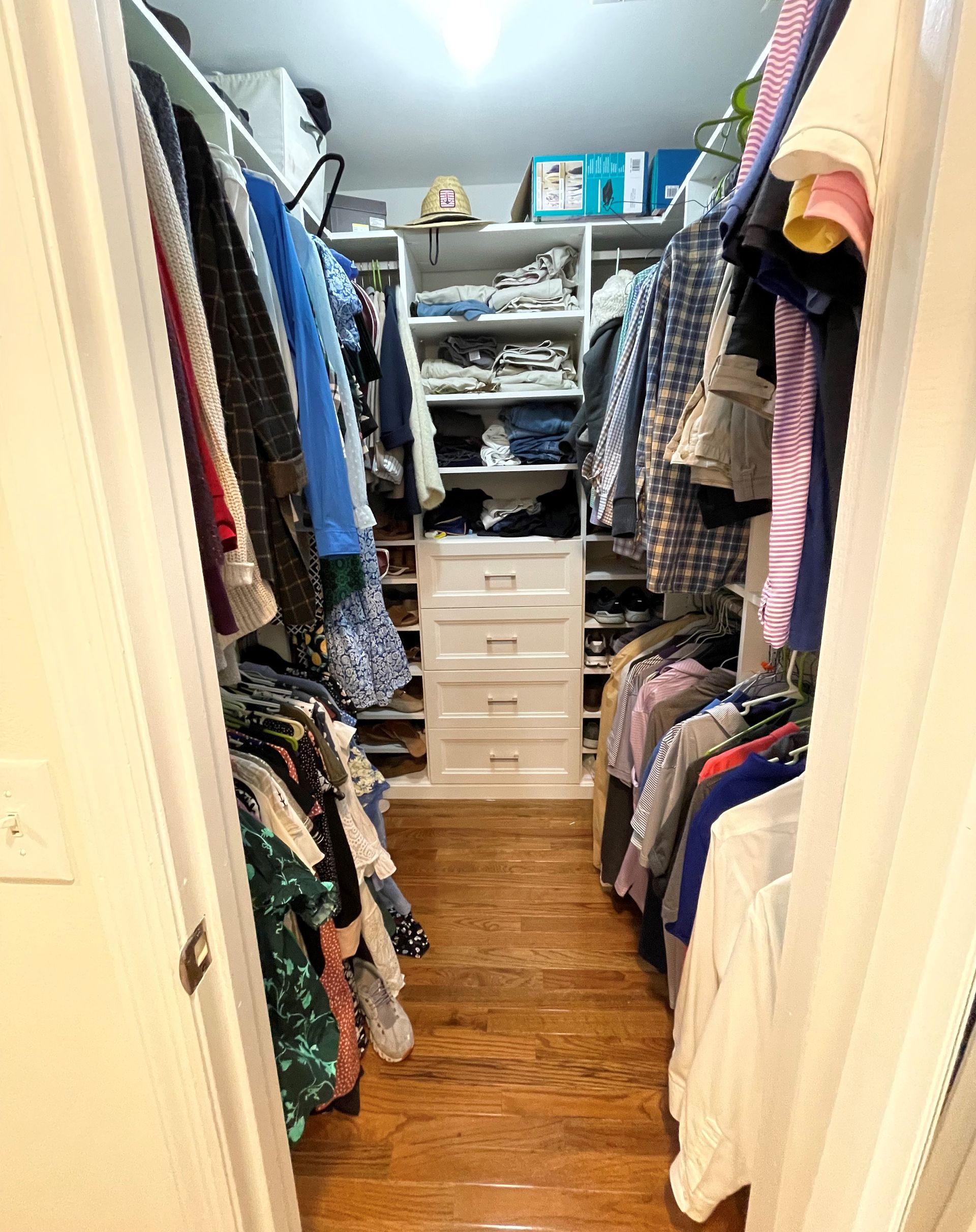 A walk in closet filled with lots of clothes and shoes.