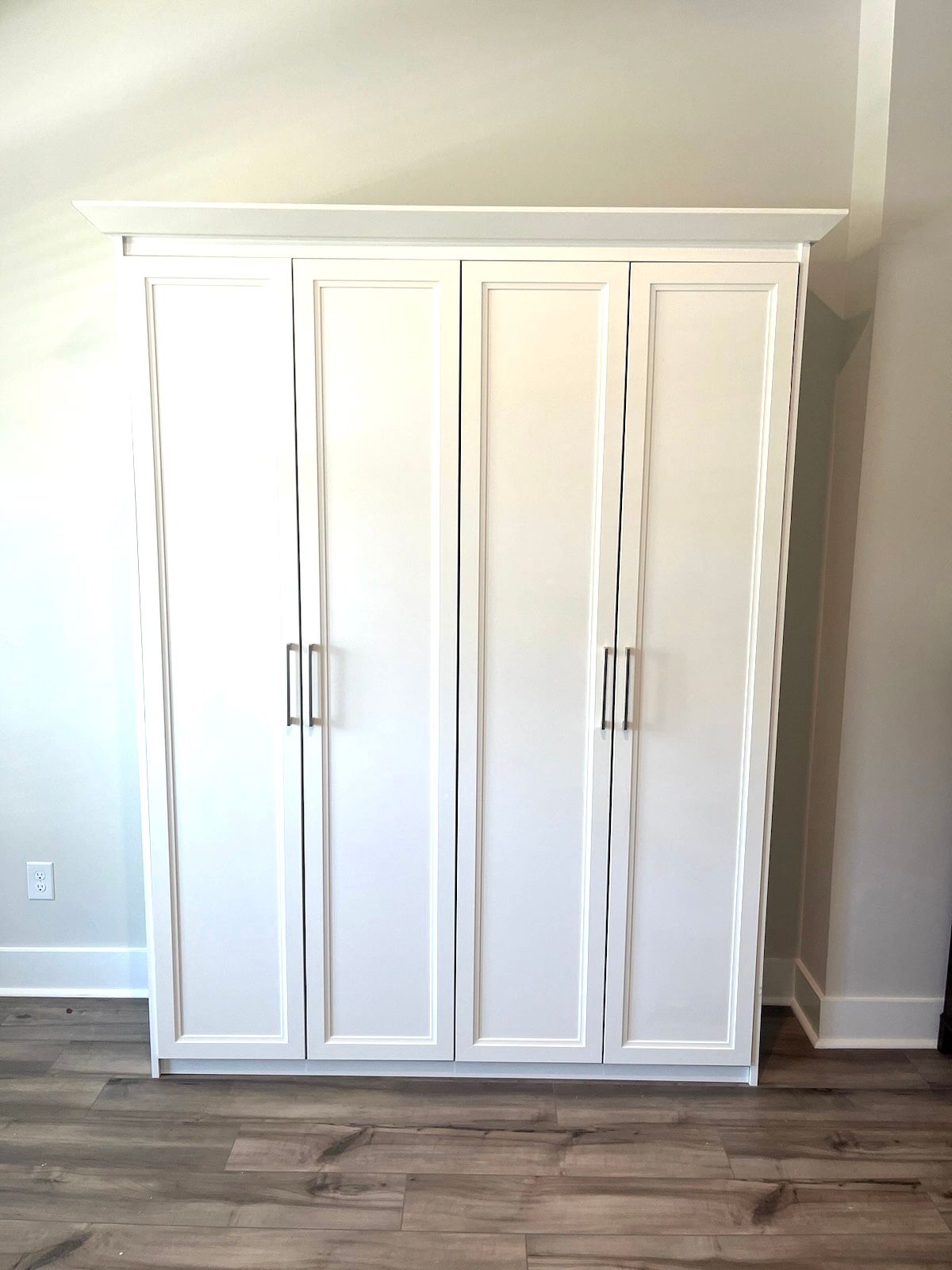 There is a large white cabinet in the middle of the room.