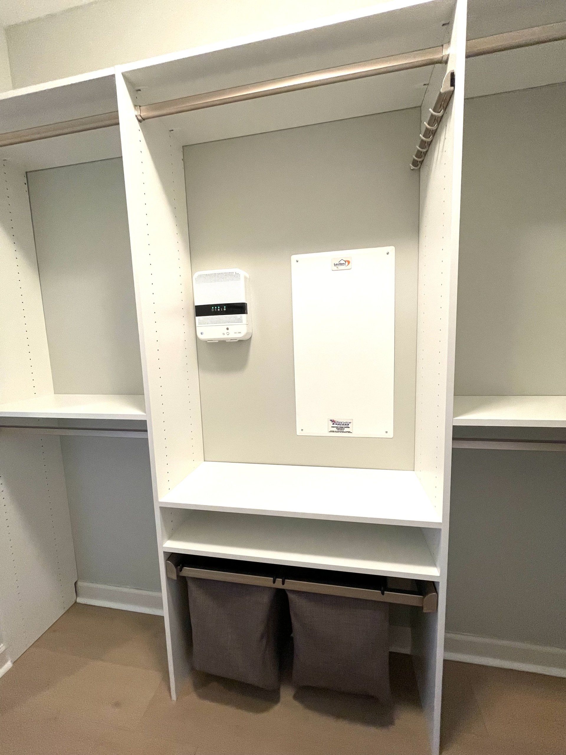 A walk in closet with a mirror and two baskets