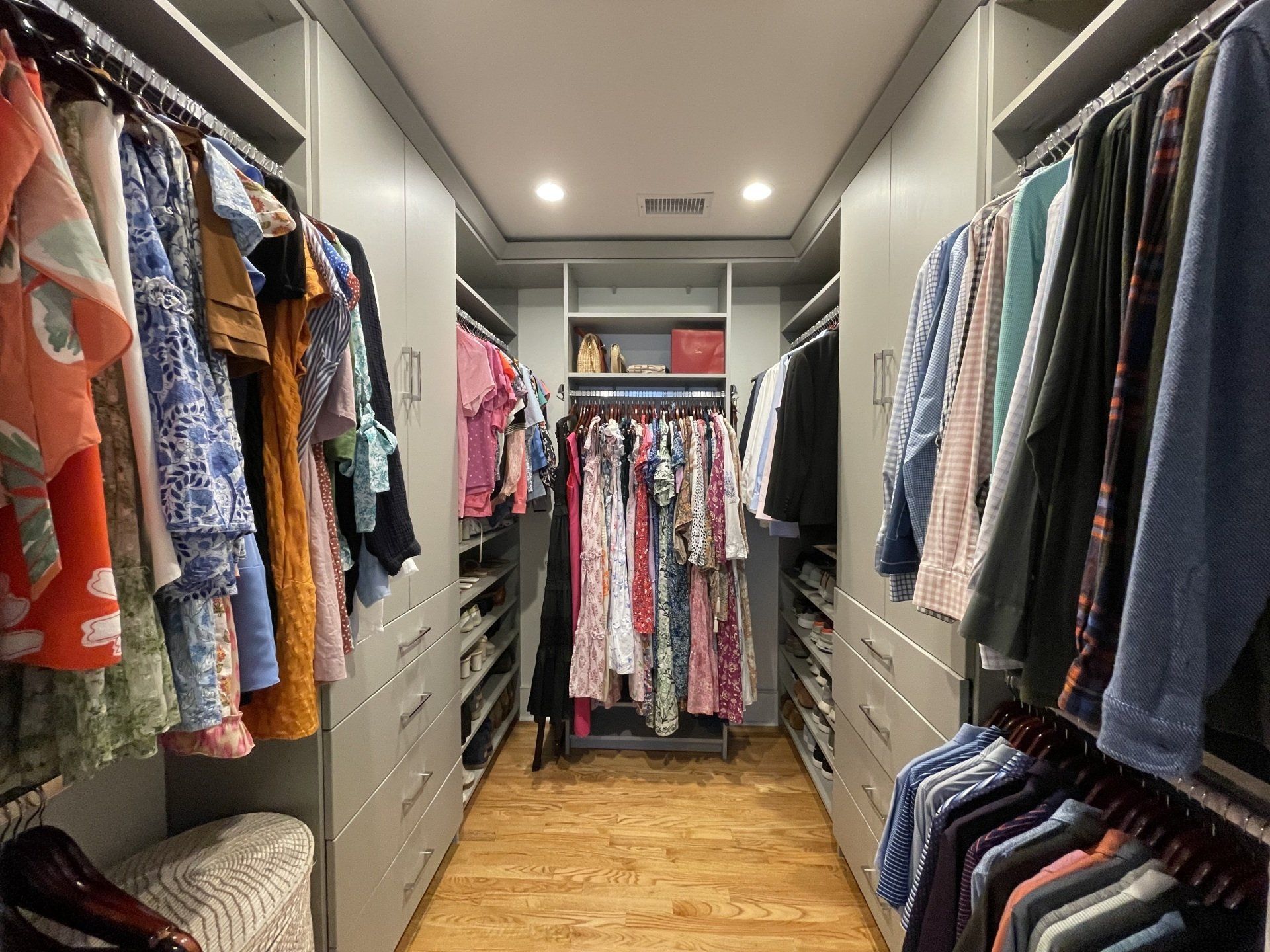 A walk in closet filled with lots of clothes.