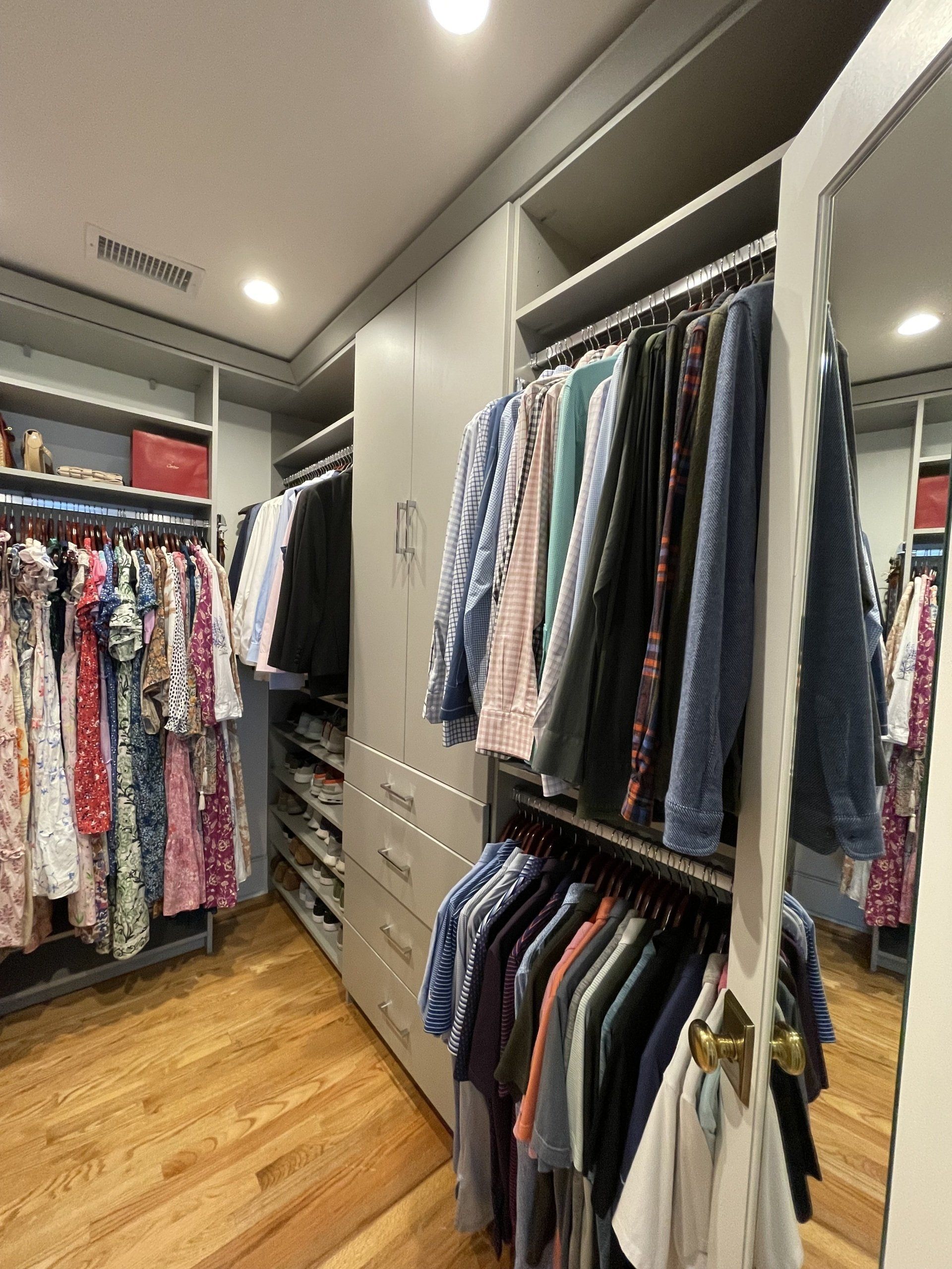 A walk in closet filled with clothes and a mirror
