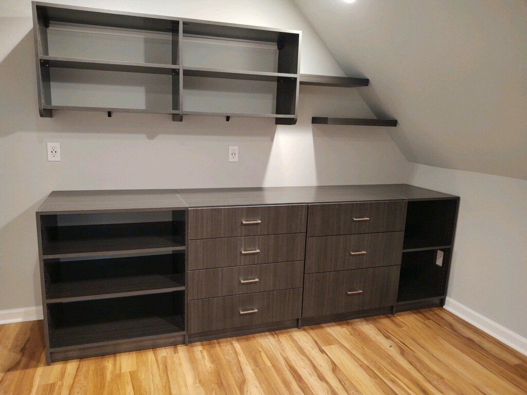 A room with a lot of shelves and drawers and a wooden floor.