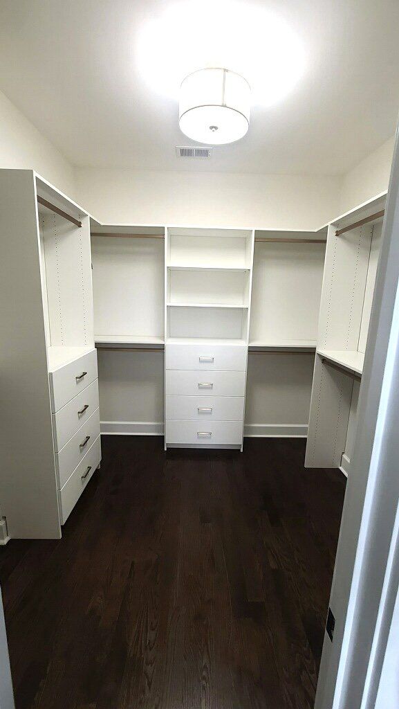 A walk in closet with lots of shelves and drawers.