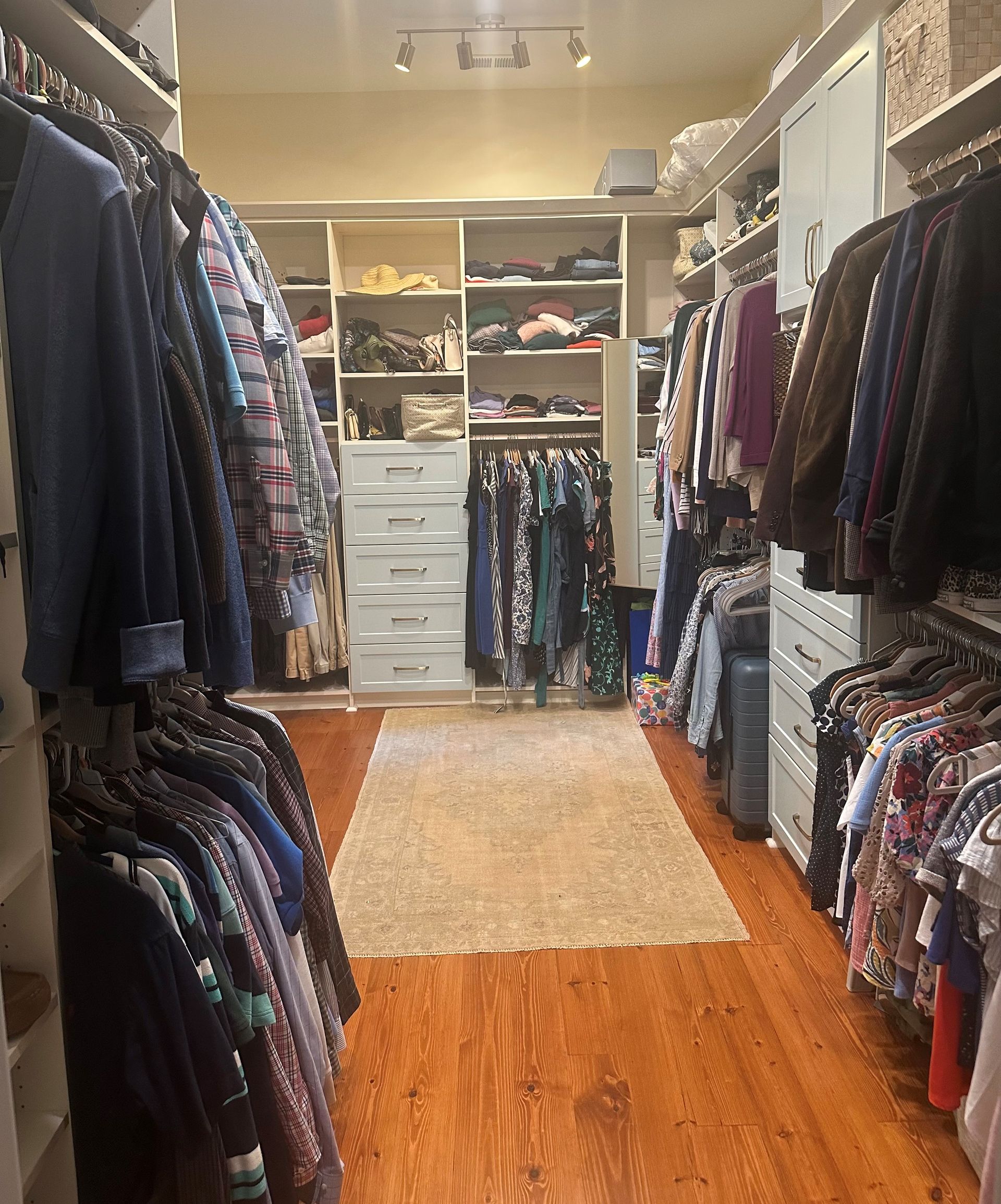 A large walk in closet filled with lots of clothes.