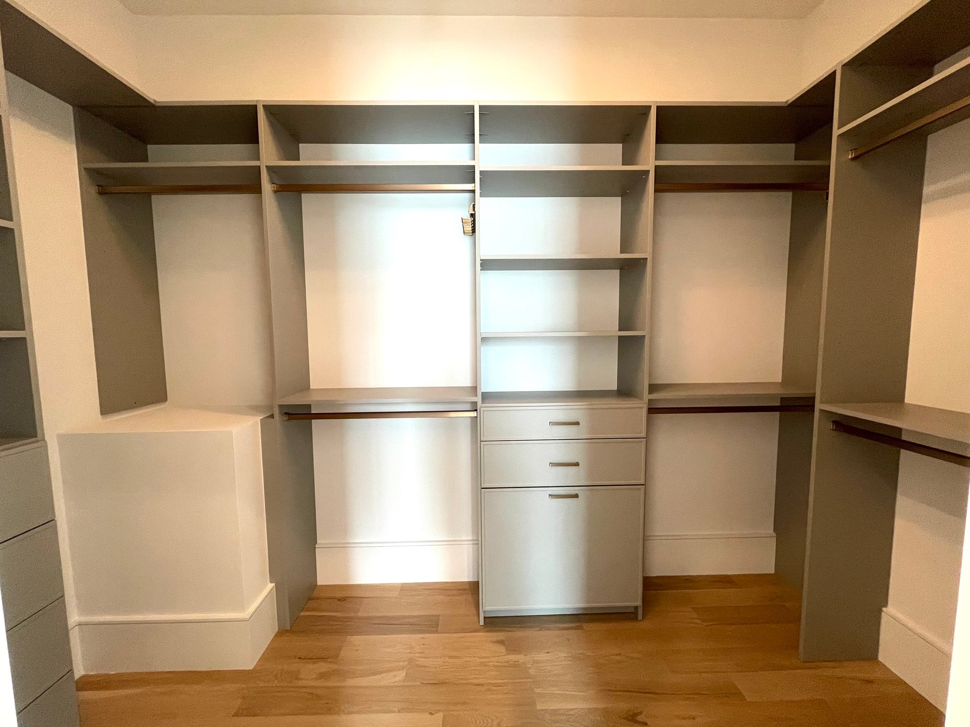 A walk in closet with lots of shelves and drawers.