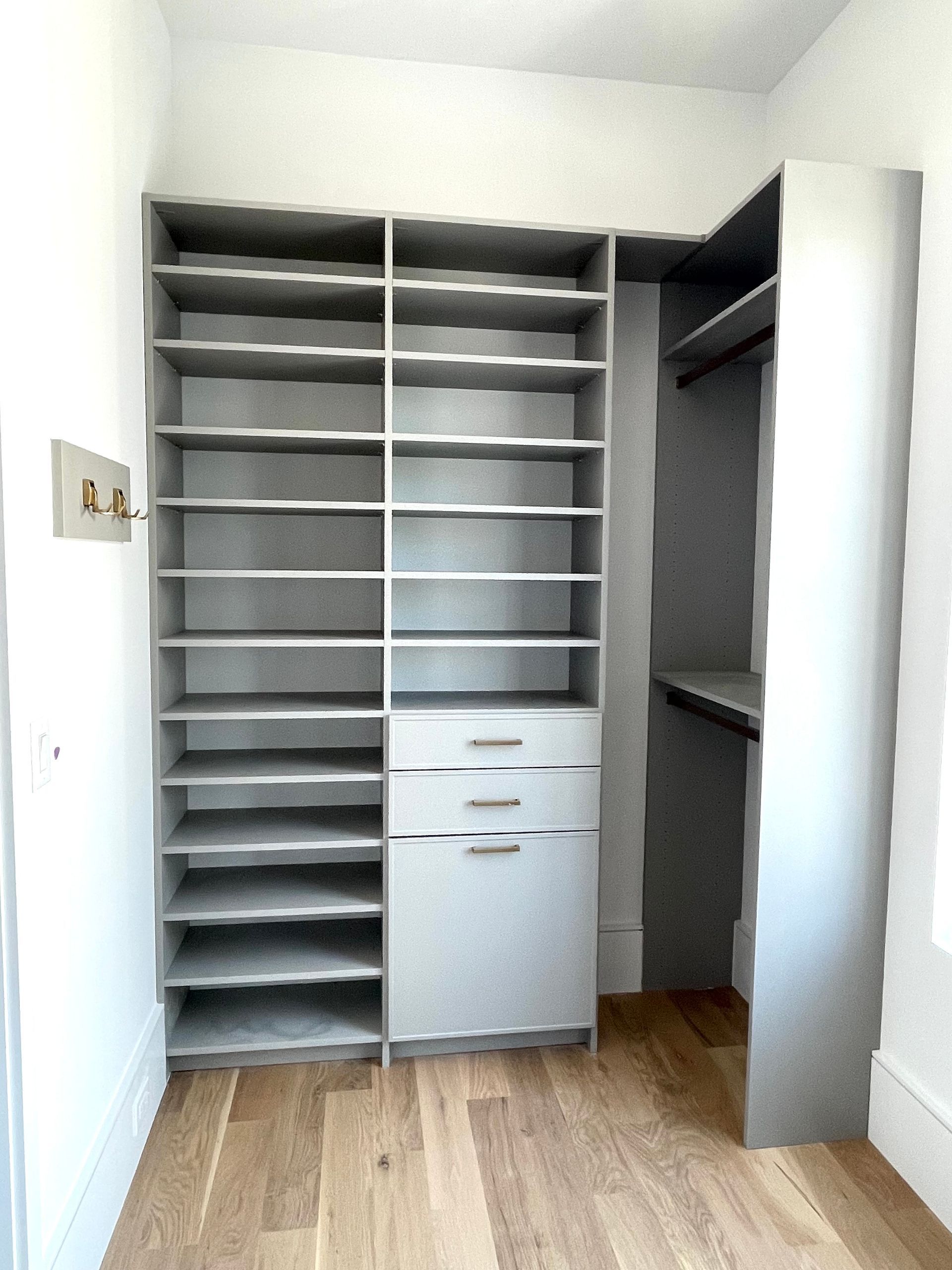 A walk in closet with lots of shelves and drawers