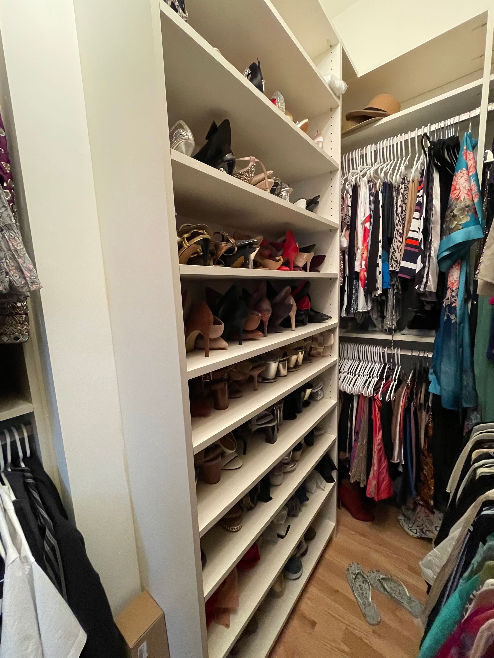 A closet filled with lots of clothes and shoes.