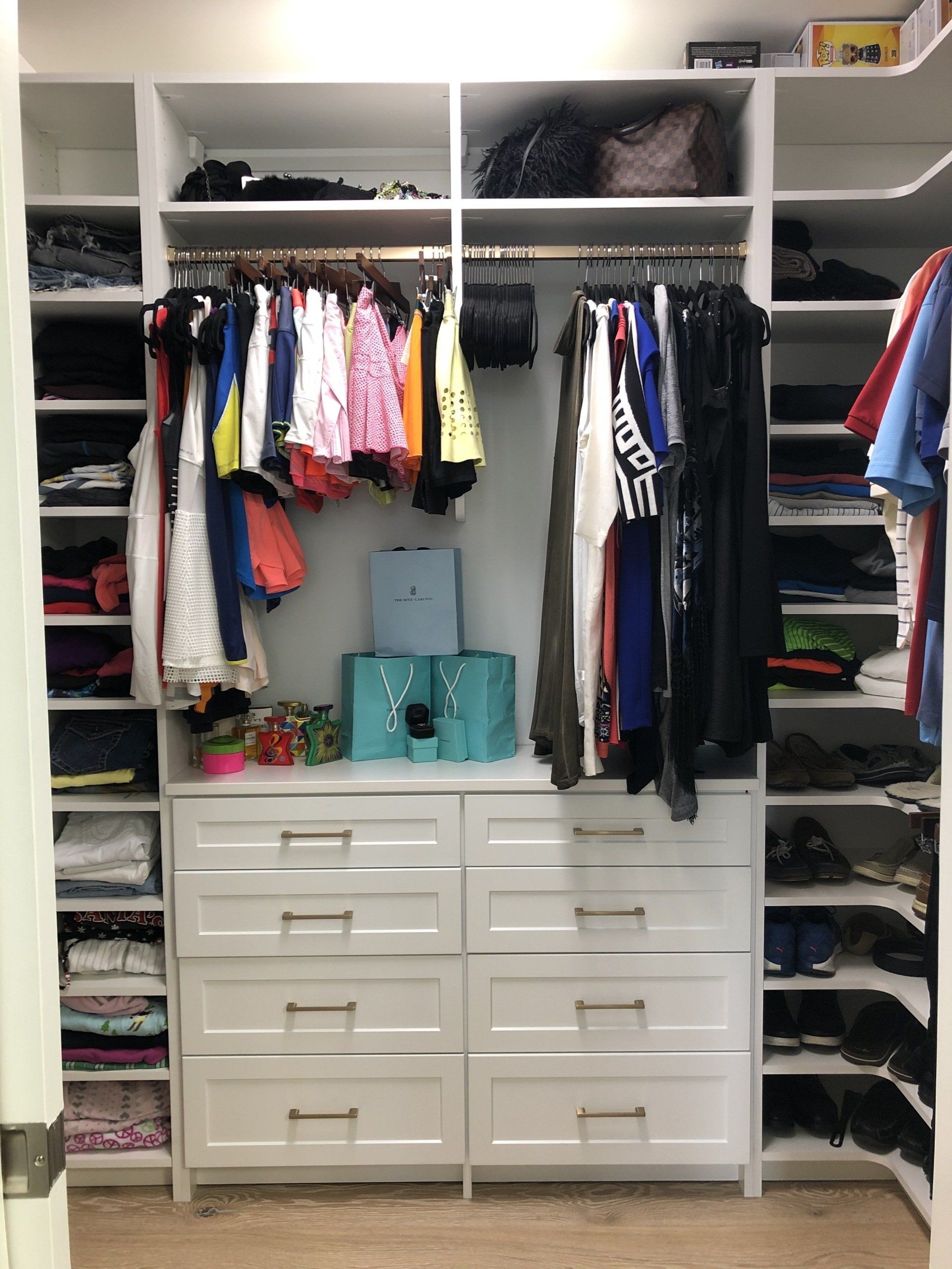 A walk in closet filled with lots of clothes and shoes.