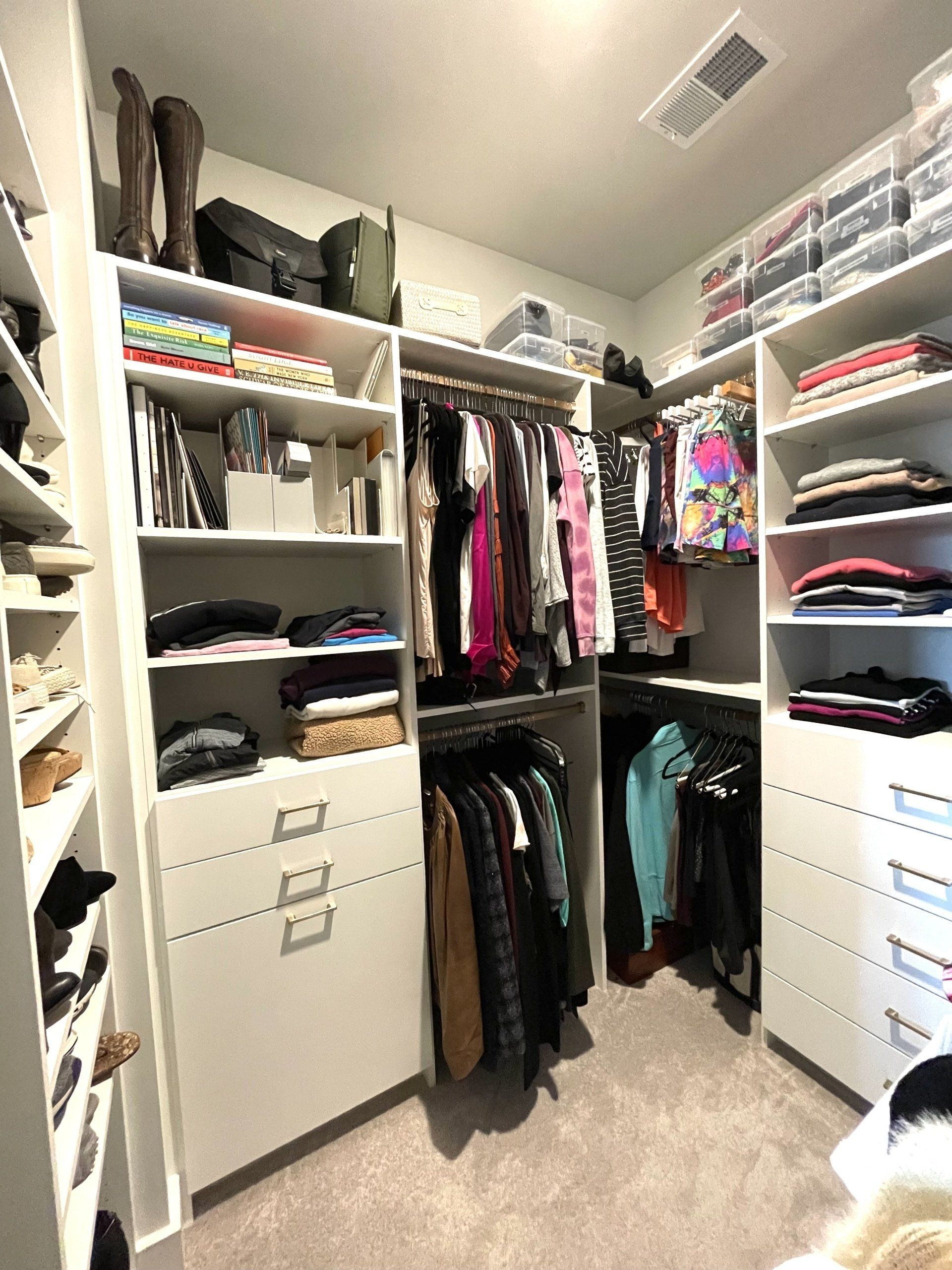 A walk in closet filled with lots of clothes and shoes.