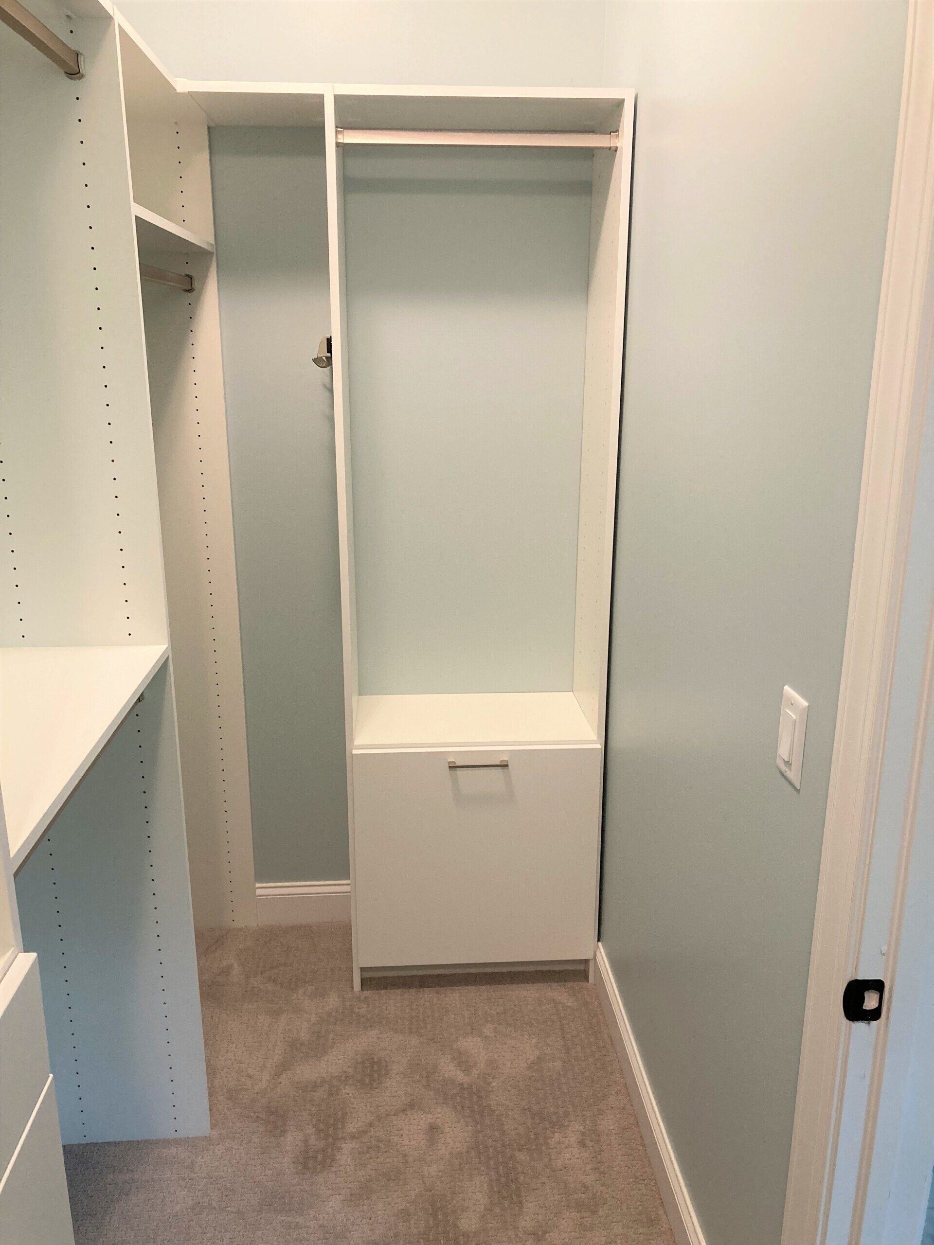 A walk in closet with white shelves and a drawer.