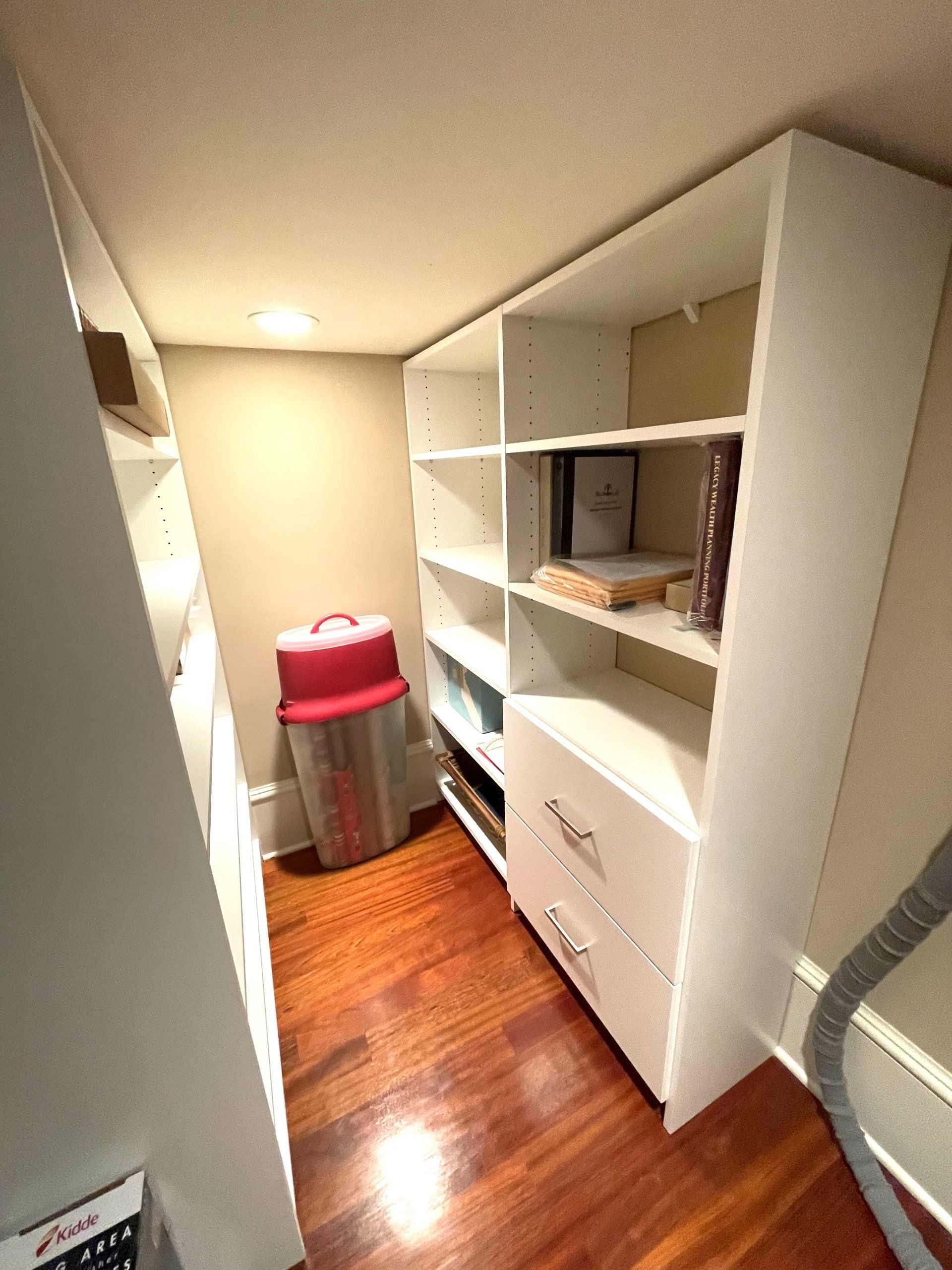A walk in closet with lots of shelves and drawers.