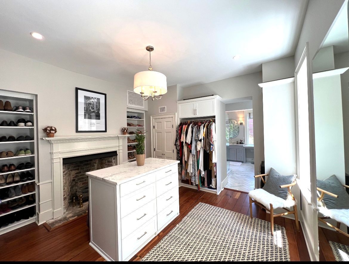A walk in closet with a fireplace and a large island in the middle.