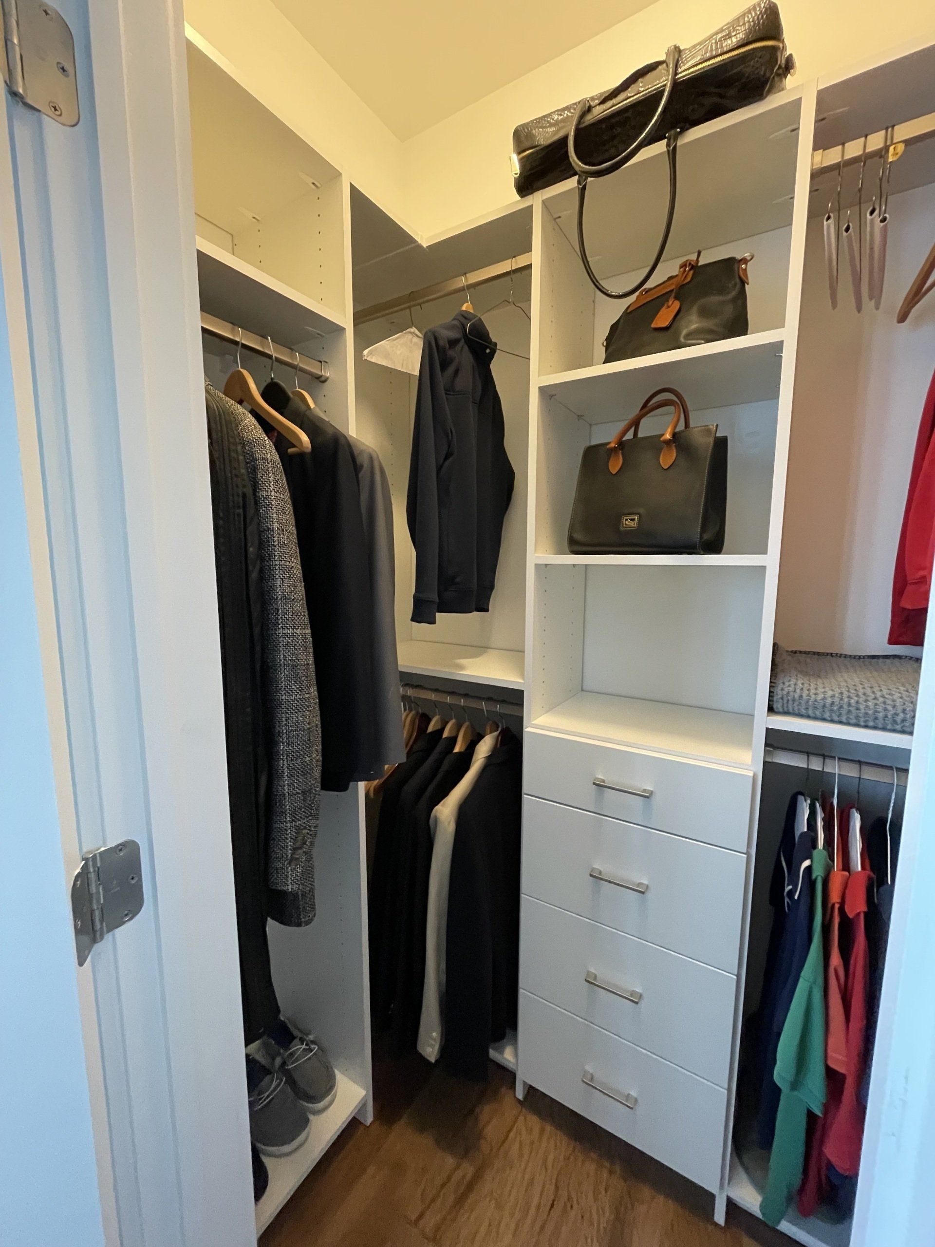A walk in closet filled with clothes and bags.