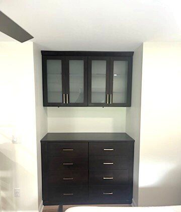 A bedroom with a dresser and drawers and a ceiling fan.