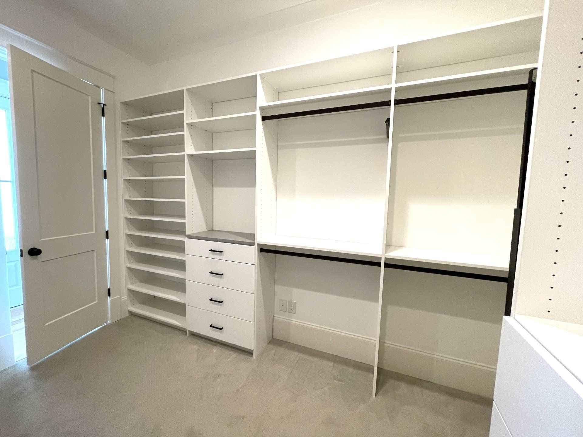 An empty walk in closet with lots of shelves and drawers.