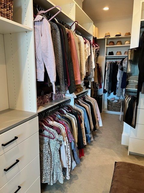 A walk in closet filled with clothes and hats
