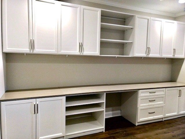 A kitchen with lots of white cabinets and drawers