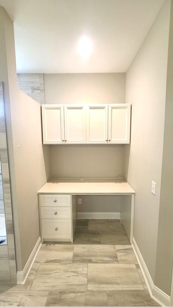 A small room with a desk and cabinets in it.