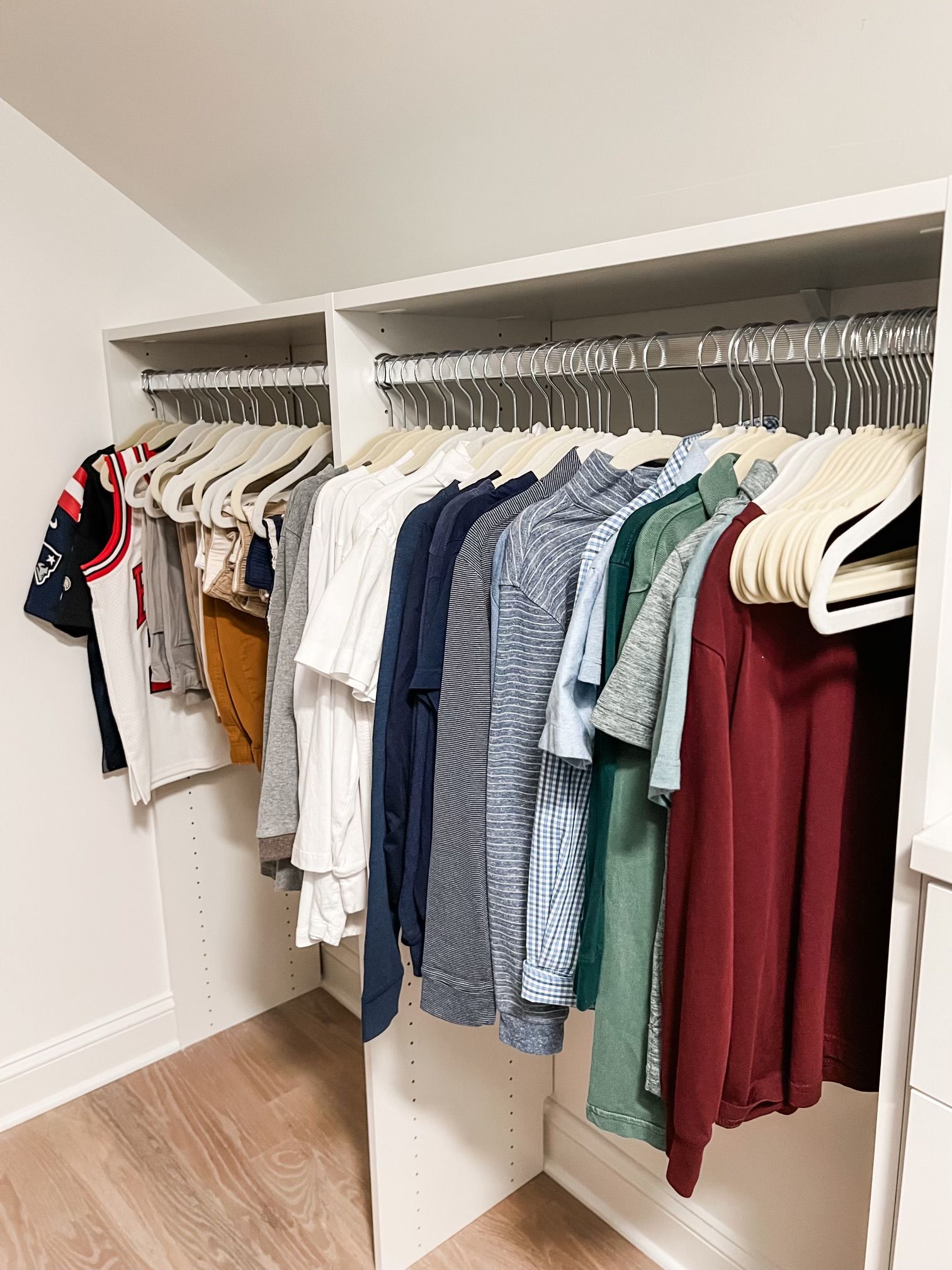 A walk in closet filled with clothes and hangers.