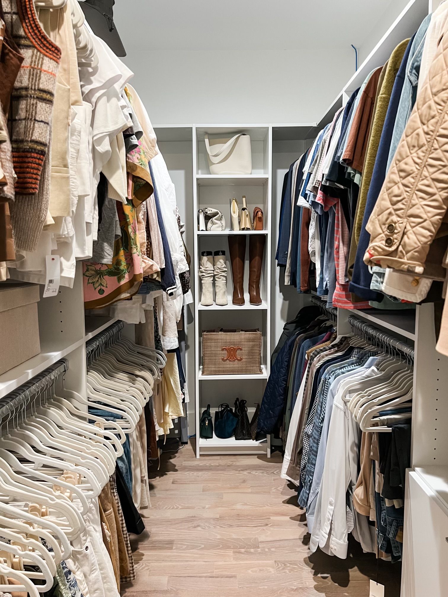 A walk in closet filled with lots of clothes and shoes.