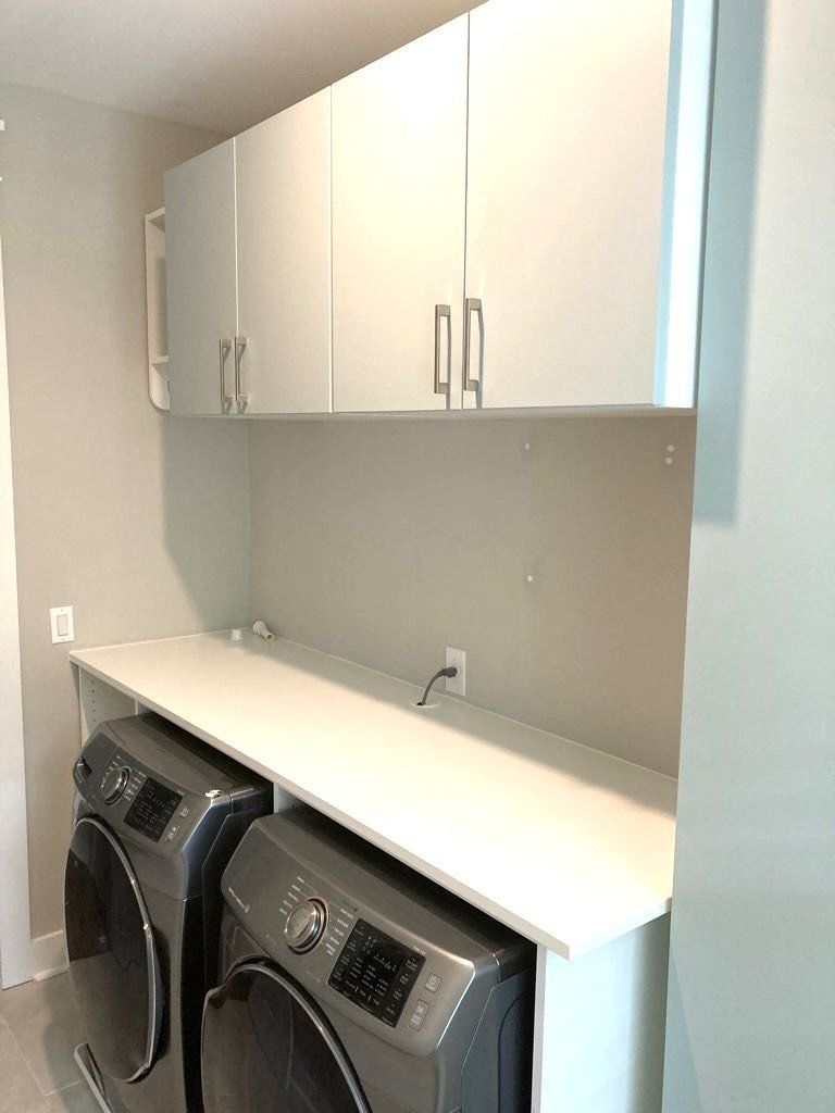A laundry room with a washer and dryer on a counter.