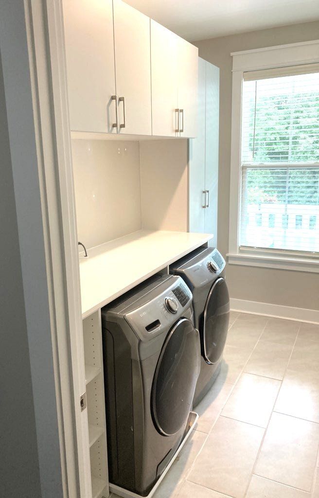 A laundry room with a washer and dryer and a window.