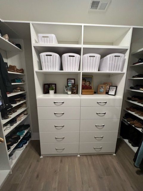 A walk in closet with lots of drawers and shelves