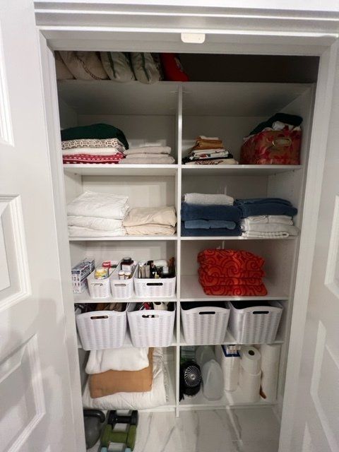 A closet filled with lots of clothes and baskets