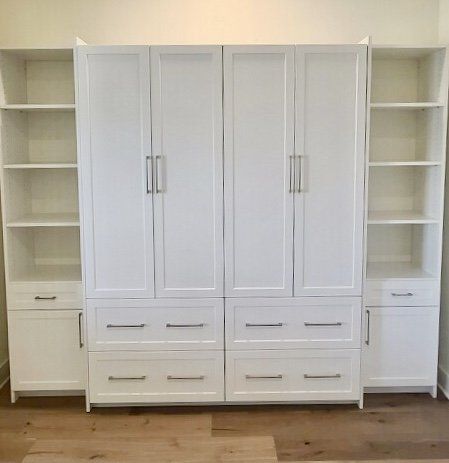 A large white cabinet with drawers and shelves in a room.