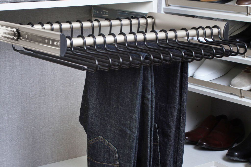 A pair of jeans hanging on a rack in a closet