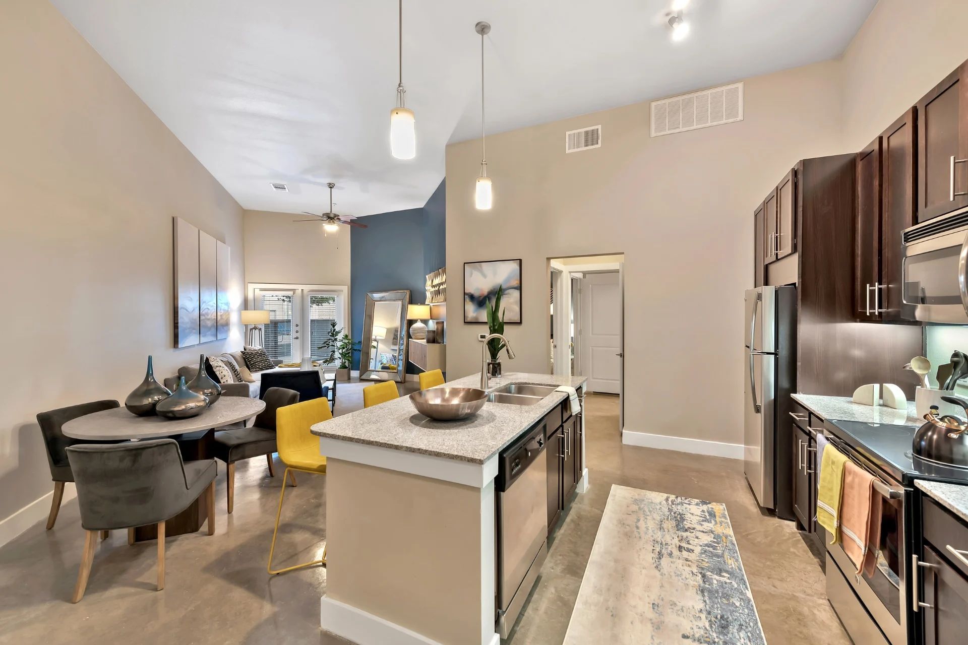A kitchen with stainless steel appliances and a large island in the middle of the room.