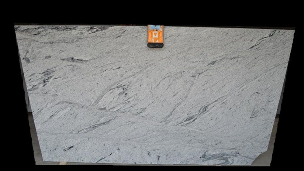A white granite slab is sitting on top of a black table.