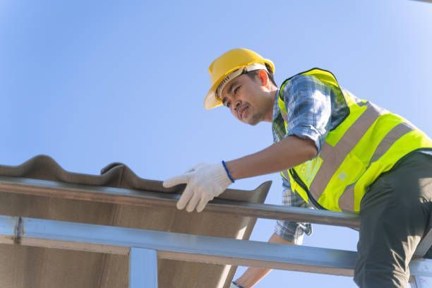 Construction worker installing roof tiles at construction site