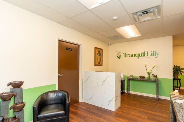 Spa reception area with a front desk, waiting area, and Tranquil Lilly logo.