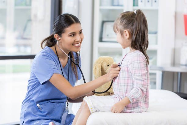 A smiling nurse taking care of a girl in an urgent care clinic.