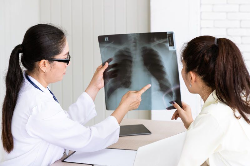 A doctor is explaining an x-ray to a patient.