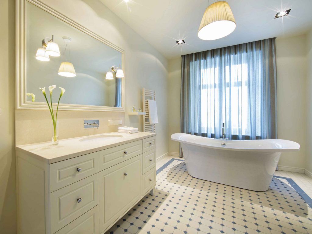 Elegant bathroom with white tub, vanity, and floral patterned floor.