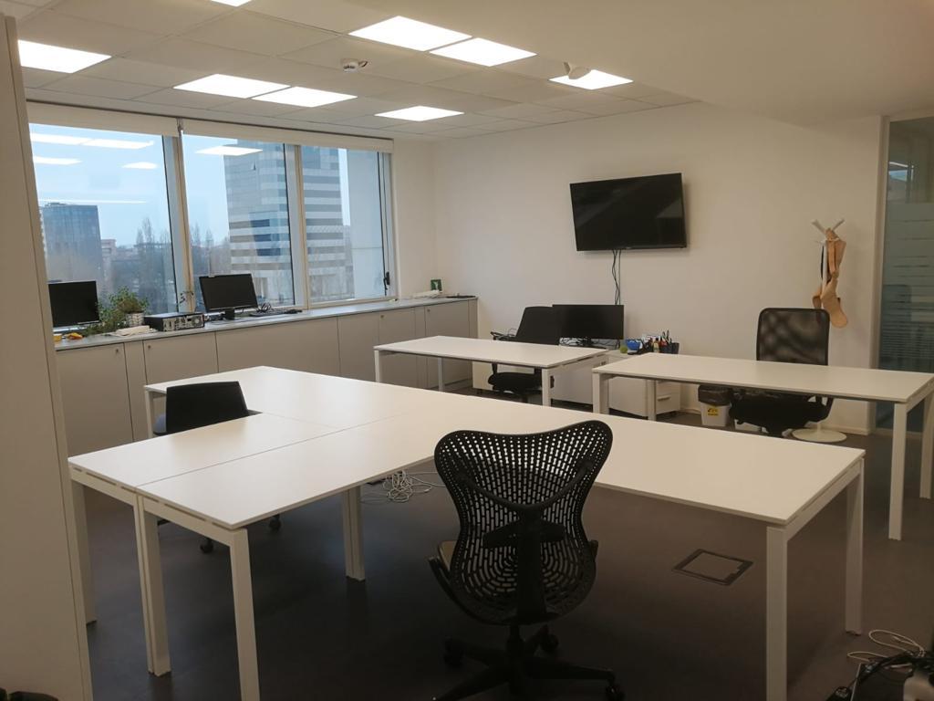 ufficio con scrivanie bianche e sedie nere