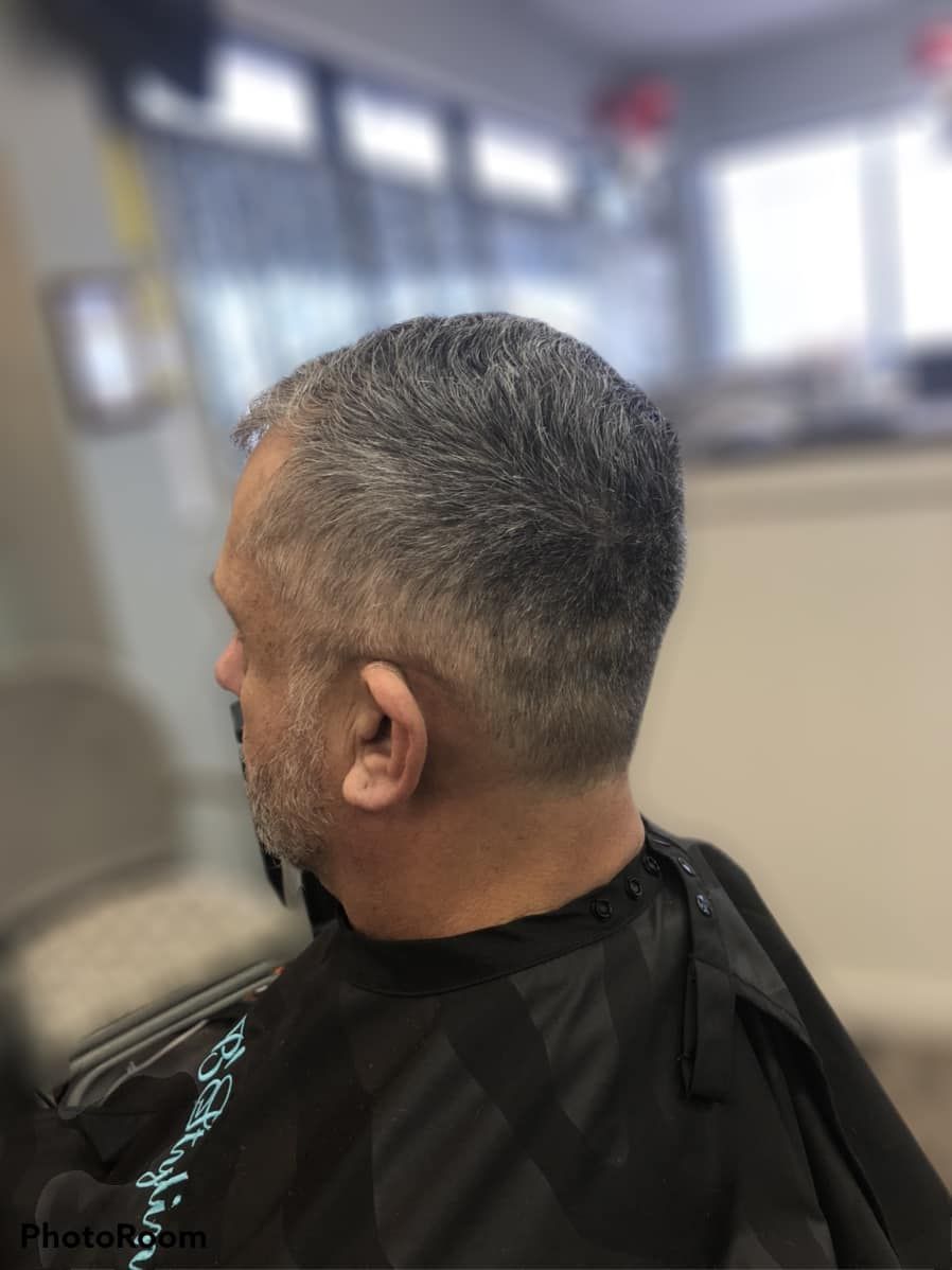 A man is getting his hair cut at a barber shop