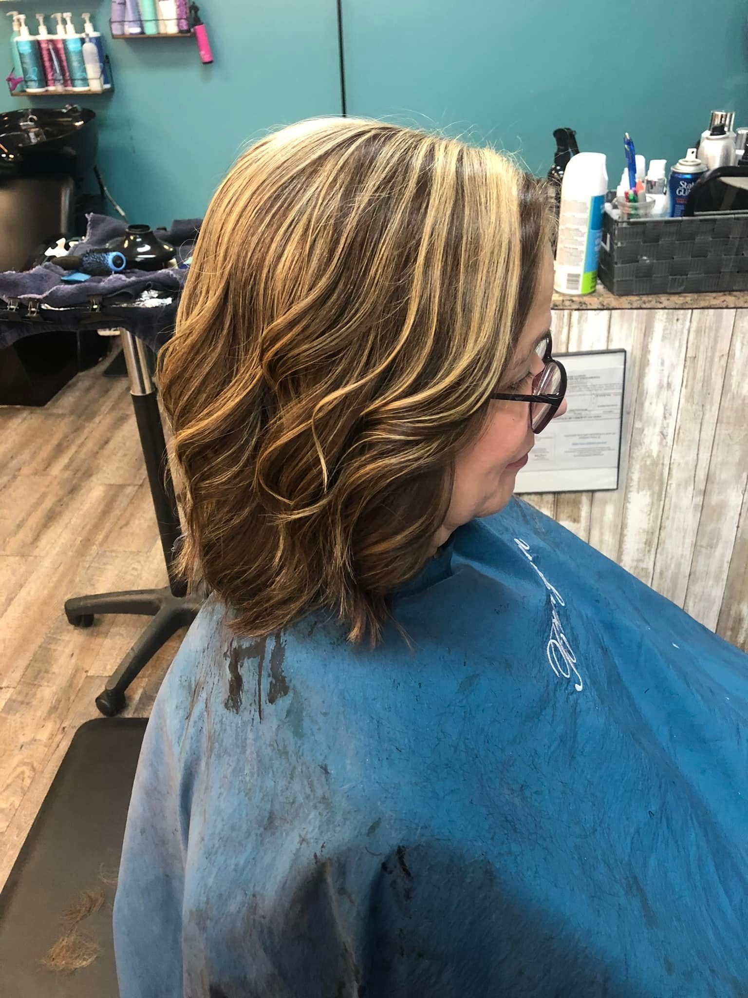 A woman is getting her hair cut in a salon.