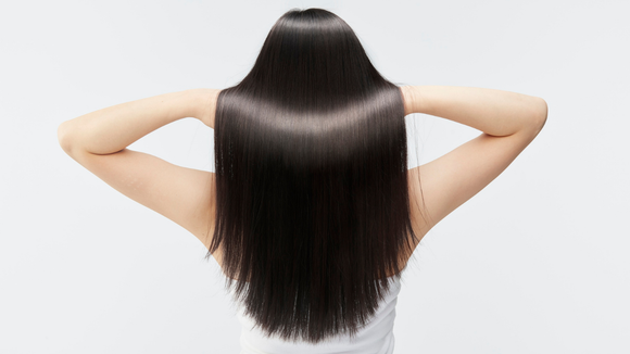 The back of a woman with long black hair.