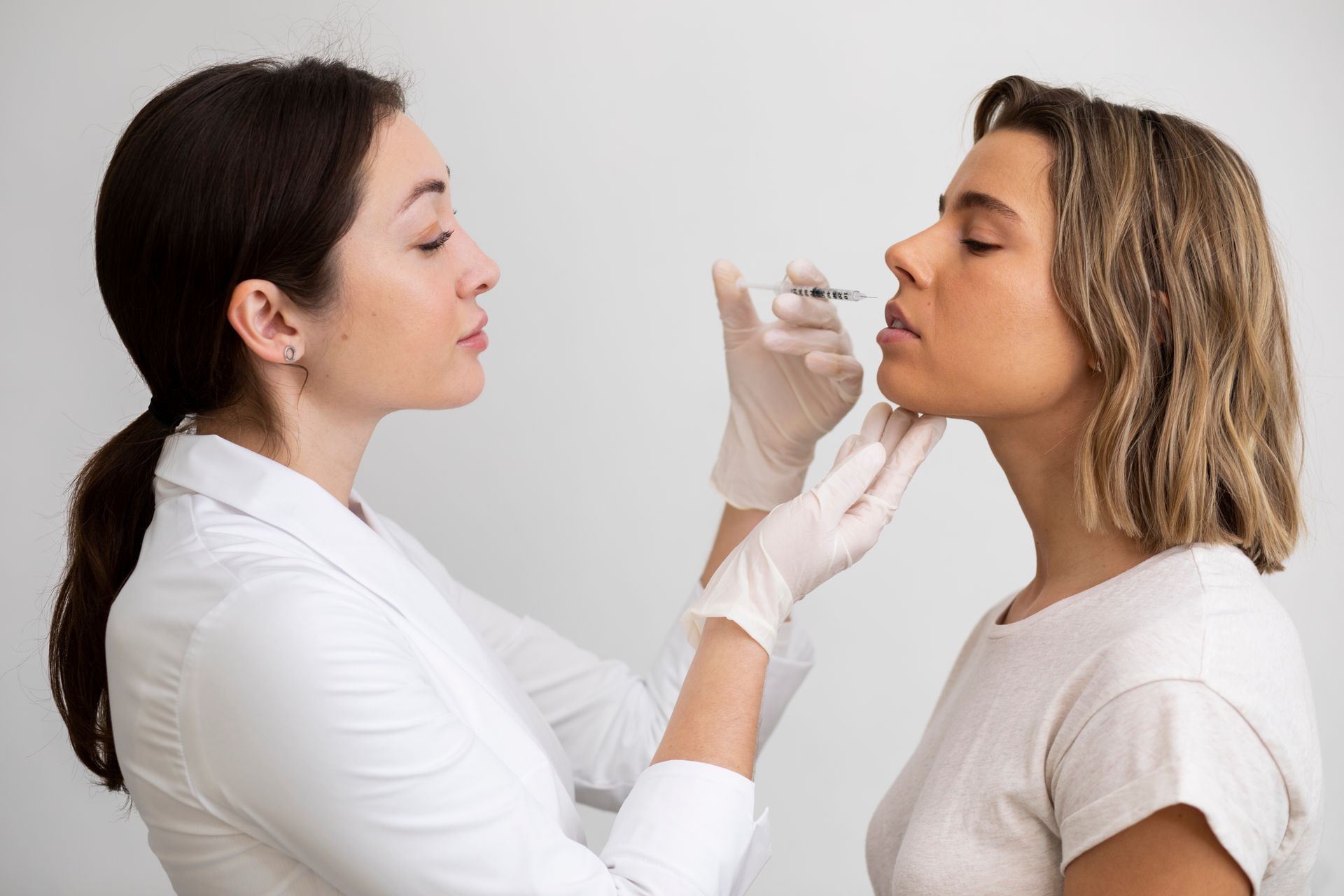 A medical professional giving a facial injection to a client.