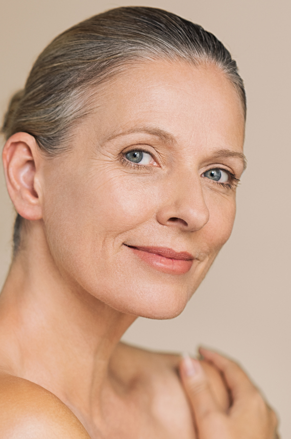 A woman is performing a microneedling procedure on a patient's face.